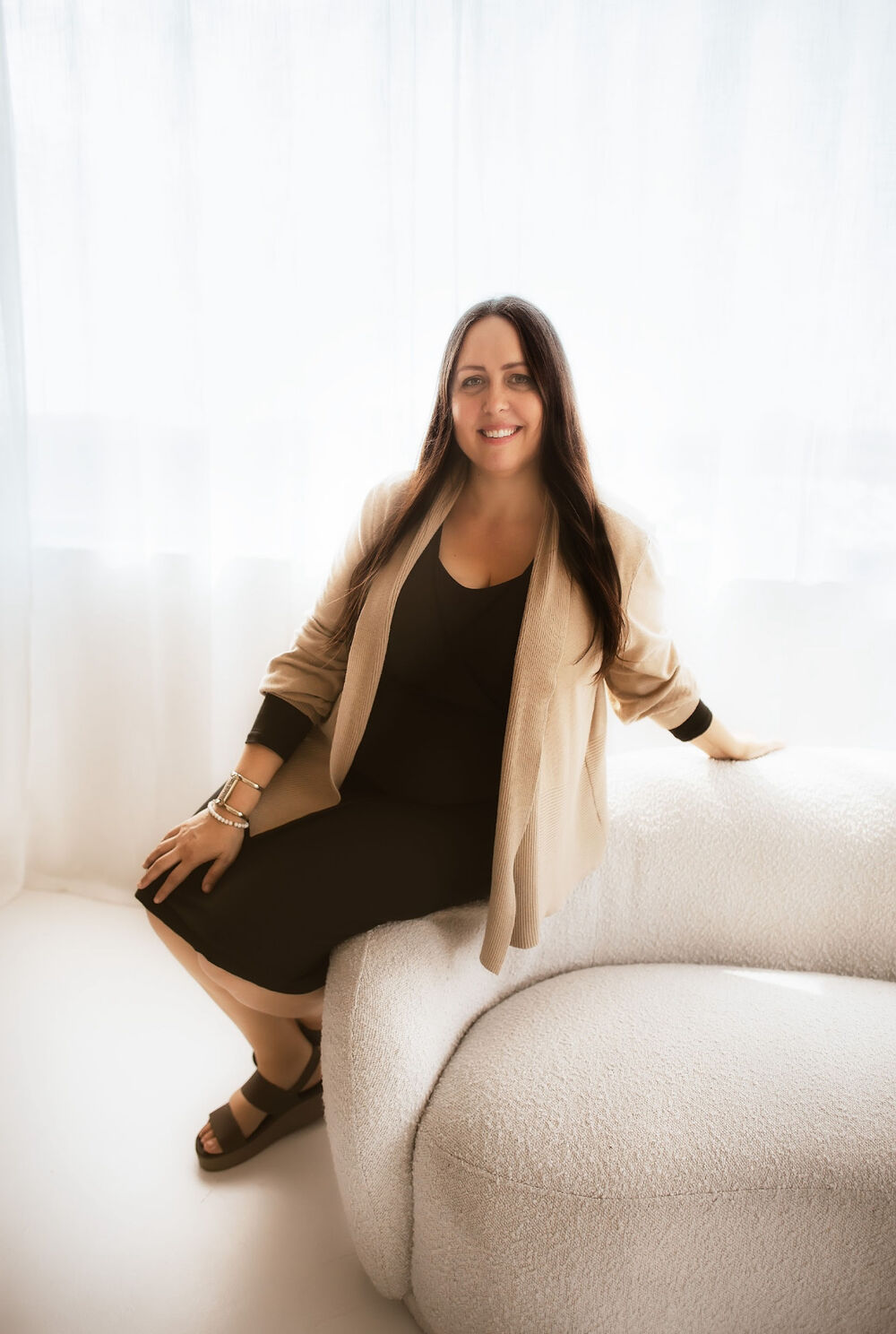 Michelle Polk, Founder & Director of Michelle Polk Collective, seated in a bright studio